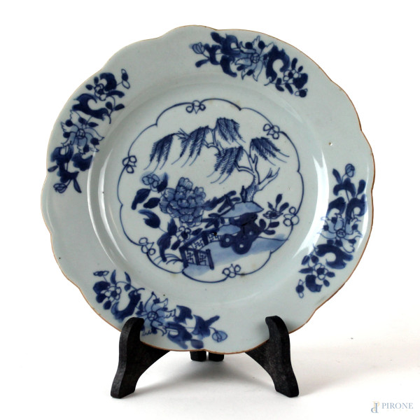Piatto in porcellana bianca e blu con decoro a motivo di paesaggio fiorito, diam. cm 23, arte orientale, XX secolo, (piccole sbeccature).