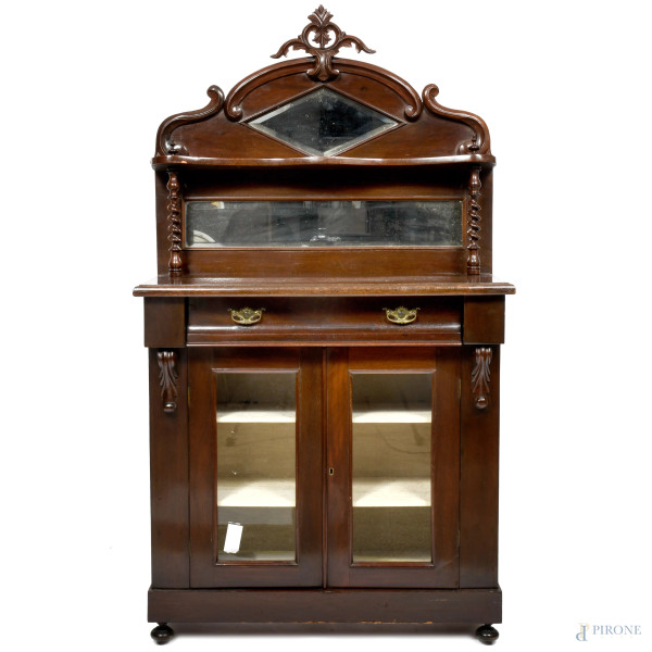 Vetrina in mogano a doppio sportello e un cassetto al fronte con alzata raccordata da due colonnine tortili. Fronte scandito da duplice specchio e piano scaffale. Elemento apicale a cimasa, XX secolo, cm 160x89x37, (difetti)