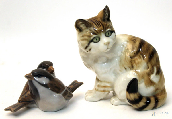 Lotto composto da due sculture in porcellana raffiguranti gatto ed uccellini, di marche diverse, H massima 12 cm.