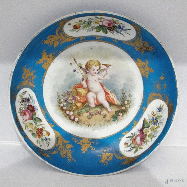 Piatto in porcellana fondo blu dipinto a motivi floreali e putto alato, Farncia XIX sec, diam. 21 cm, (difetti)