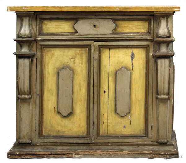 Credenza in legno laccato, XVIII secolo, piano di linea rettangolare, fronte ad un cassetto e due sportelli, particolari intagliati, cm h 99x111x49,5, (difetti e parti sostituite).