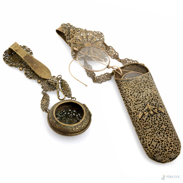 Lotto composto da portaorologio e da occhiali con portaocchiali in metallo finemente cesellato e traforato, XX secolo, misure massime cm 23,5x5,5
