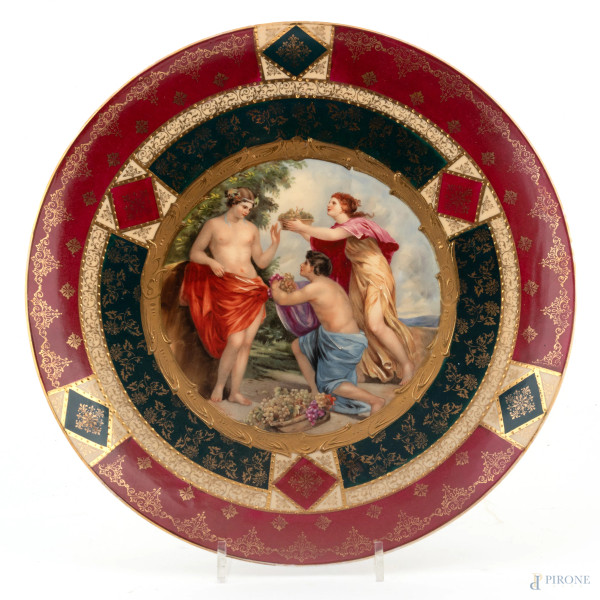 Piatto in porcellana Vecchia Vienna decorato in policromia all'orlo nei toni del rosso, verde e oro e scena mitologica al cavetto, XIX-XX secolo, diametro cm 33, (segni di usura, scoloriture)