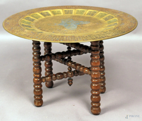 Tavolo orientale con piano circolare in rame cesellato, base in legno, diametro 45 cm, altezza 29 cm.