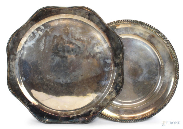 Lotto di due vassoi di linea ovale e sagomata in metallo argentato, bordi cesellati, diametro max cm 43,5, XX secolo,  (segni del tempo).