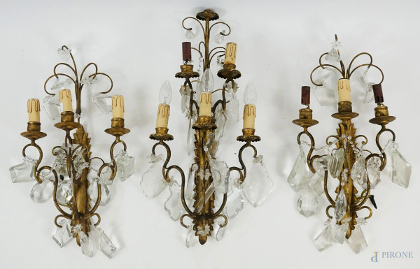 Tre applique a cinque e tre luci, in metallo dorato con pendenti in cristallo, metà XX secolo, alt. max cm 65, (difetti e mancanze)