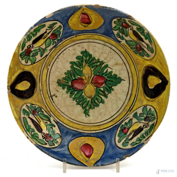 Piatto in maiolica decorato in policromia con frutti e volatili, XIX-XX secolo, diametro cm 23,5, (segni di usura, sbeccature, felature)