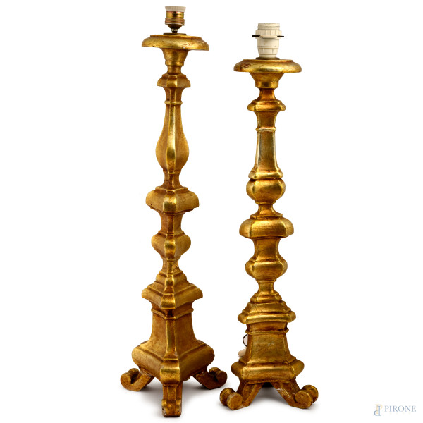 Coppia di candelieri montati a lampada in legno intagliato e dorato poggianti su tre piedi a ricciolo, XX secolo, altezza massima altezza cm 75, (difetti)