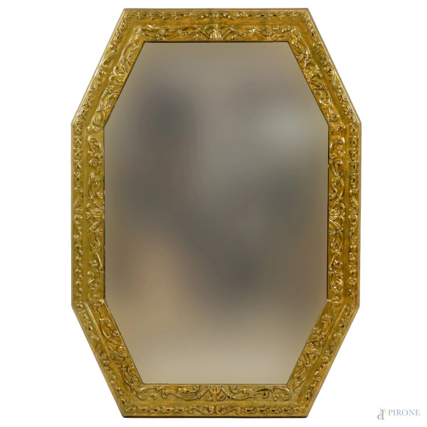 Specchiera di linea ottagonale in legno dorato, XX secolo, decori scolpiti a motivi fogliacei, cm 95x68.