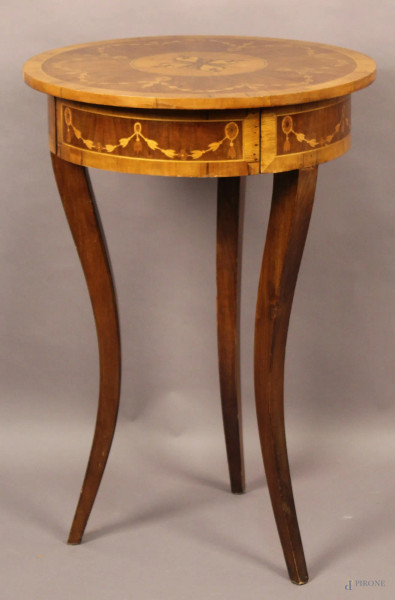 Tavolino di linea tonda a vari legni con intarsi ad un cassetto, poggiante su tre gambe a sciabola, altezza 81 cm, diametro 58 cm.