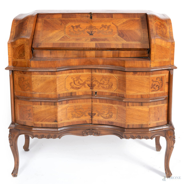 Ribalta in legno impiallacciato e intarsiato in varie essenze. fronte mosso a due cassetti sormontati da sportello a ribalta celante piano scrittoio e cassetti, XX secolo, cm 94x32x37, (segni di usura, scalfiture, difetti)