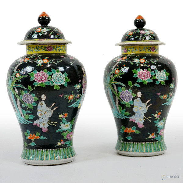 Coppia di potiches con coperchio in porcellana, Cina, XX secolo, decorate con rappresentazioni di figure femminili e fanciulli su fondo nero, cm h 42, (difetti)