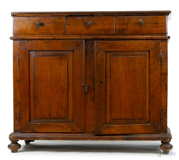 Credenza in legno dolce tinto a noce, XIX secolo, fronte a tre cassetti e due sportelli, cm h 105x118x42, (difetti).