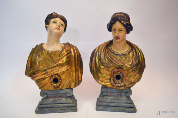 Santa Apolloni a e Santa Lucia, coppia di busti in legno intagliato e dorato, poggianti su basu, XVIII sec, h. 29 cm.