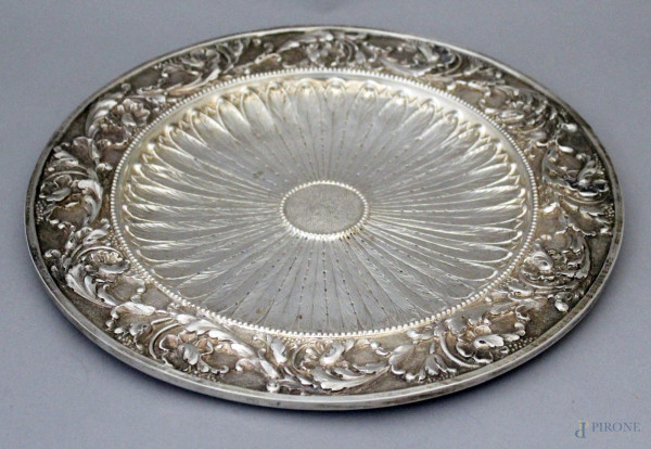 Piatto di linea tonda in argento sbalzato e finemente cesellato a decoro di foglie d&#39;acanto, XIX sec, diametro 34 cm, gr. 710.