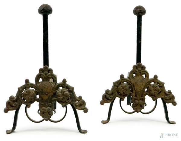 Coppia di alari in ferro battuto, decoro frontale a volute con scudetto centrale, cm 35x38x23, XX secolo, (difetti)