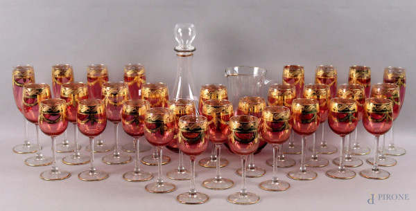 Lotto di calici in vetro rosa con decori dorati, composto da: otto flute, dieci acqua, dodici vino, una bottiglia e una caraffa, altezza max. 31 cm.