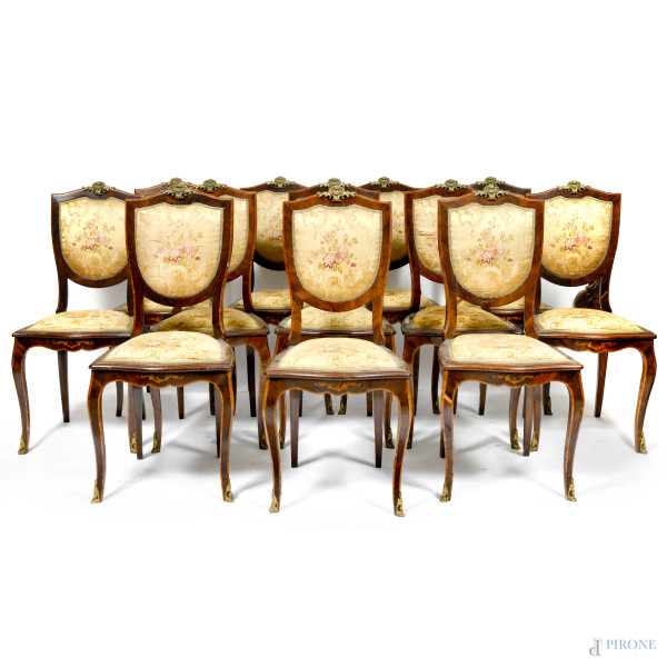 Lotto di 12 sedie in legno impiallacciato e intarsiato in varie essenze con inserti in bronzo dorato. Sedute e schienali imbottiti e rivestiti in tessuto decorato a motivi floreali XIX-XX secolo, cm 101,5x47x47 (segni di usura, graffi, difetti, scalfiture, fori di tarlo)