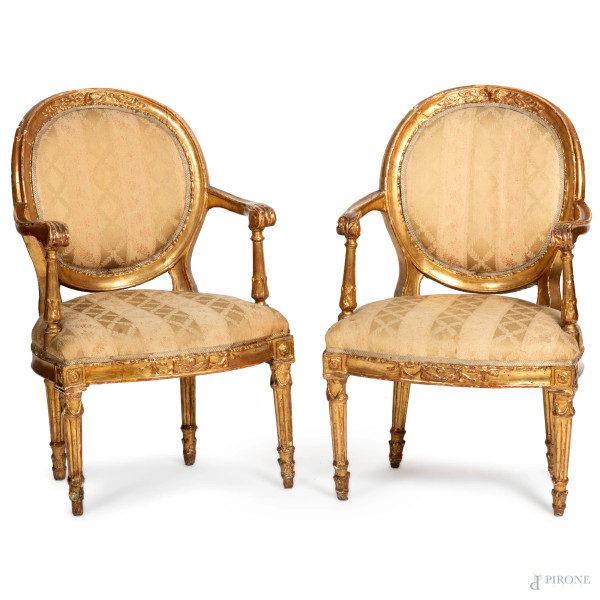 Coppia di poltrone in legno dorato e intagliato con schienale, seduta e braccioli imbottiti e rivestiti in tessuto color panna e oro a motivi floreali, XIX secolo, cm 98,5x62x55, (segni di usura, scalfiture, difetti)