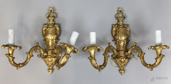 Coppia di appliques in bronzo dorato e cesellato, a due luci, altezza cm 32