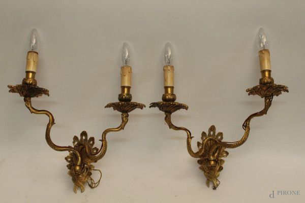 Coppia di applique a due luci in bronzo dorate, H 38 cm.