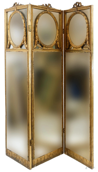 Paravento a tre ante in legno dorato, inizi XX secolo, pannelli a specchi decorati da festoni e cimase a nodo d’amore, misure singolo pannello cm 173x48x3,(difetti)
