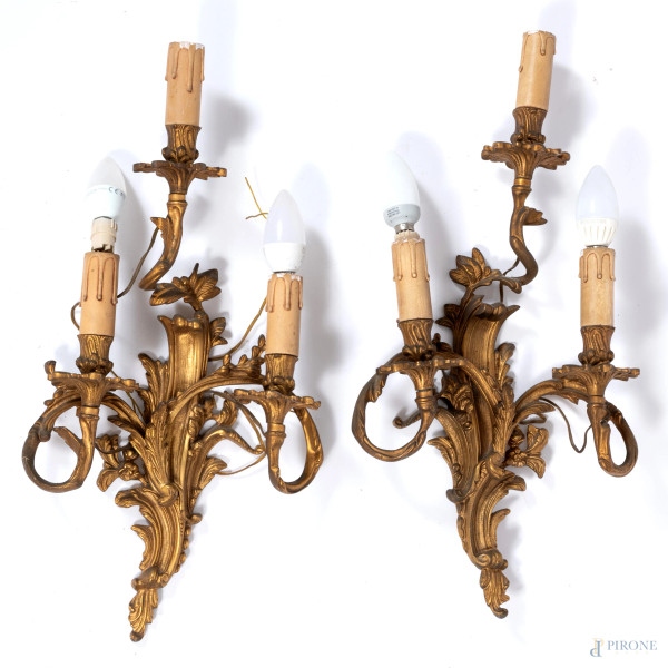 Coppia di appliques a tre luci in bronzo dorato e cesellato a volute vegetali e racemi fioriti, XX secolo, cm 52x26x12,5, (segni di usura, cadute di doratura, da revisionare)