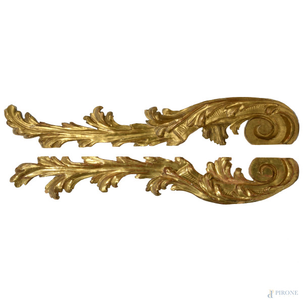 Coppia di elementi decorativi in legno intagliato e dorato, XX secolo, misure cadauno cm 26x152,5, (fessurazioni, scalfiture, cadute di doratura, fori di tarlo)