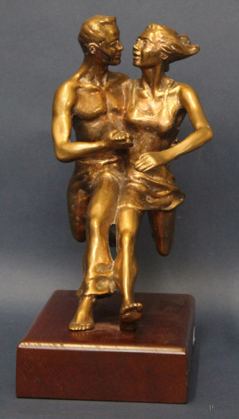 Corsa di coppia, scultura in bronzo dorato poggiante su base in legno, H 28 cm.