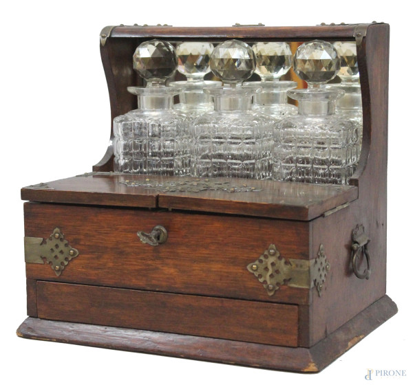 Tantalus porta bottiglie in rovere, ad un cassetto ed un piano a due sportelli con divisori all'interno, finiture in bronzo, completo di tre bottiglie in cristallo, cm h 33x34x25, fine XIX secolo, (segni del tempo).