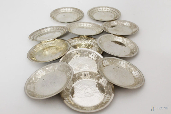 Lotto di dodici piattini in argento, gr. 1060, diam. 12 cm.
