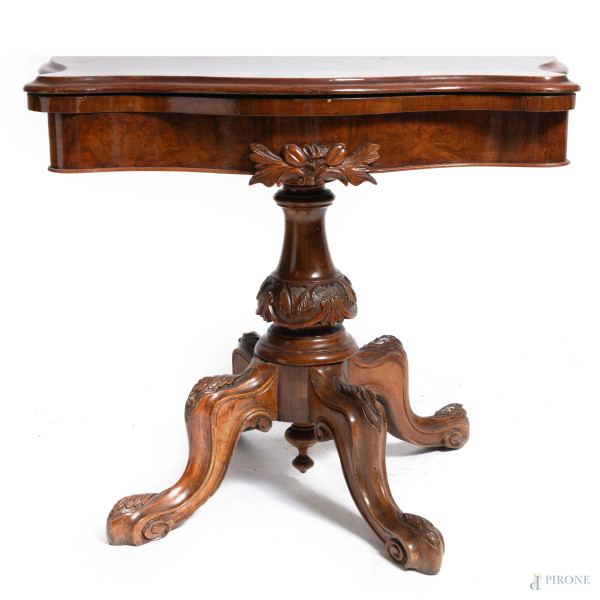 Tavolo da gioco in legno impiallacciato e intagliato con piano apribile celante area rivestita in tessuto verde, XIX secolo, misure chiuso cm 69x89x44, misure aperto cm 67x89x88, (segni di usura, difetti, sollevamenti impiallacciatura)