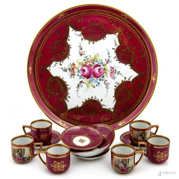 Lotto composto da un vassoio in porcellana Rue de la Paix e sei tazzine e sei piattini in porcellana Meissen nei toni del magenta e dell'oro con decori a scene di genere, XX secolo, diametro vassoio cm 33, (segni di usura, difetti)
