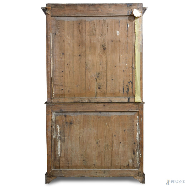 Credenza in legno dolce con corpo inferiore scandito da cassettone e doppia anta, corpo superiore...