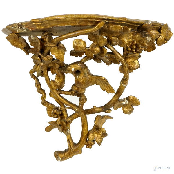 Mensola in legno dorato, XVIII-XIX secolo, piano sagomato sorretto da intaglio a ramages con aquila ed acini d'uva, cm 47x56x25, (difetti e restauri)