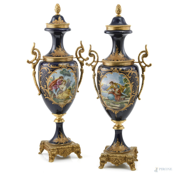 Coppia di potiche in metallo dorato e porcellana nei toni del blu e dell'oro con scene galanti, XX secolo, altezza cm 46, (segni di usura)