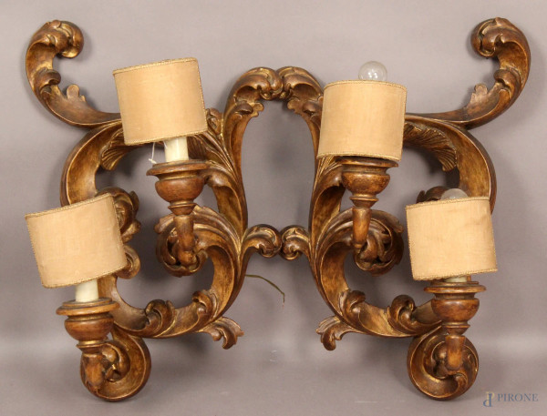 Coppia di appliques a due luci in legno intagliato e dorato a forma di foglie d&#39;acanto, primi &#39;900, altezza 64 cm.