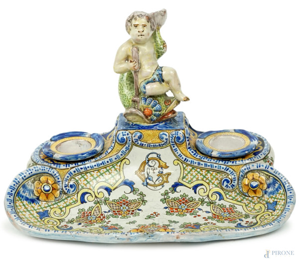 Calamaio in maiolica policroma, sommità ornata da piccolo amorino su animale marino, cm h 17,5x25x17, Francia, marchio di Antoine Montagnon (Nevers).