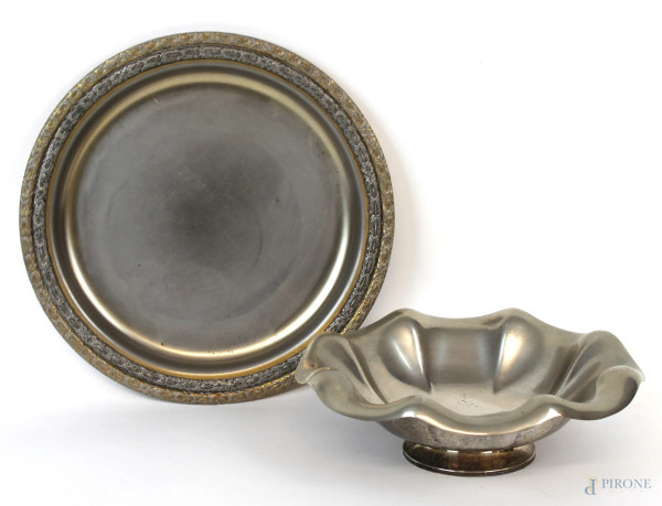 Lotto di due centrotavola in metallo argentato, bordo cesellato,  diam. max cm 26, XX secolo, (segni del tempo).