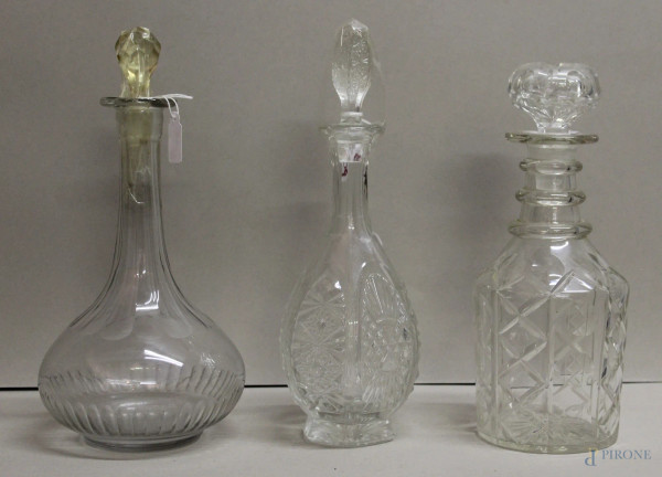 Lotto di tre bottiglie in cristallo molato e sfaccettato, h.max 25 cm.