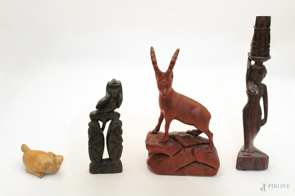 Lotto di quattro sculture diverse in legno, h.  max 34 cm.