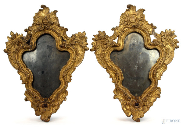 Coppia di specchiere di linea sagomata in legno e pastiglia dorata, XIX secolo, cm h 57, (difetti e mancanze).