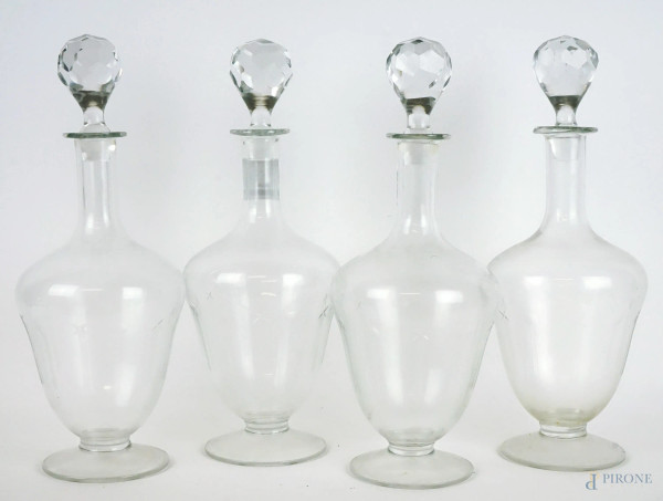 Lotto di quattro bottiglie in vetro, tappi in cristallo, cm h 32, XX secolo.