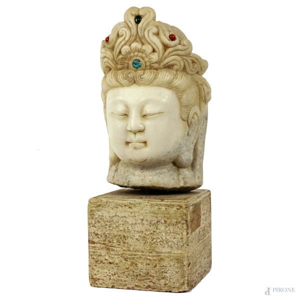 Testa di Buddha, scultura in marmo,  cm h 22, base in travertino,  XX secolo.