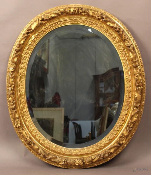 Specchiera dell&#39;800 di linea ovale in legno dorato con fiori a rilievo, altezza 83x70 cm.
