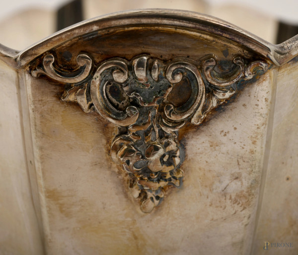 Centrotavola in argento di forma ovale con profilo polilobato con due manici e poggiante su quatt...