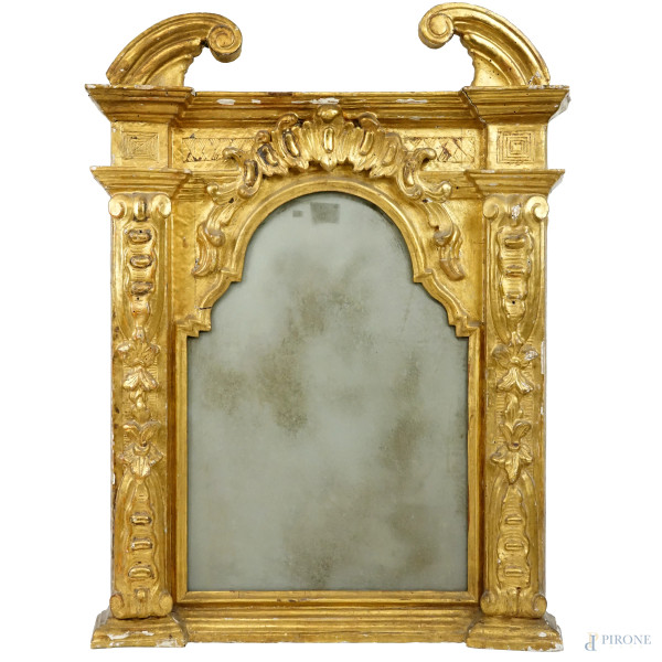 Specchiera in legno dorato e scolpito, XVIII secolo, cimasa modanata aggettante sormontata da volute laterali a ricciolo, particolari intagliati e ingombro cm 78x59, (difetti)