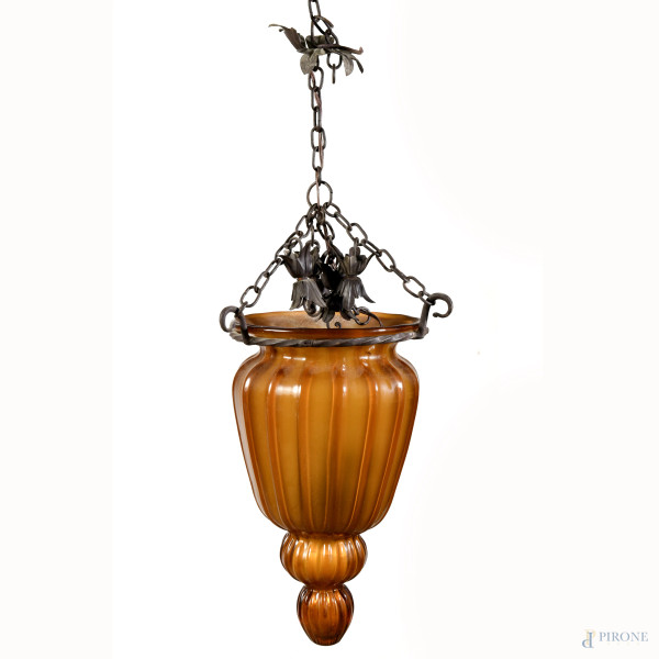Lampada a sospensione con struttura in ferro battuto e diffusore in vetro nei toni dell'arancio, XX secolo, misure diffusore cm 42x24 circa, (segni di usura, difetti, da revisionare)