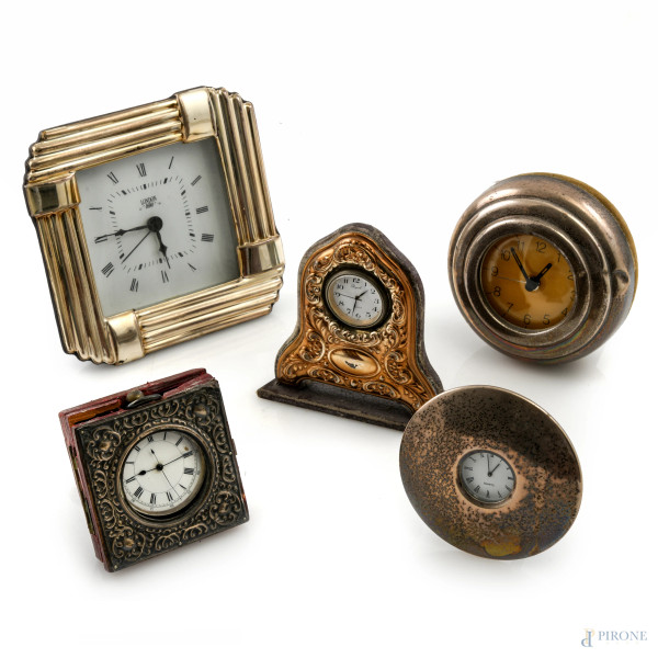 Lotto di 5 orologi di varia foggia rivestiti in argento, XX secolo, misure massime cm 14x14, (segni di usura, difetti, da revisionare)