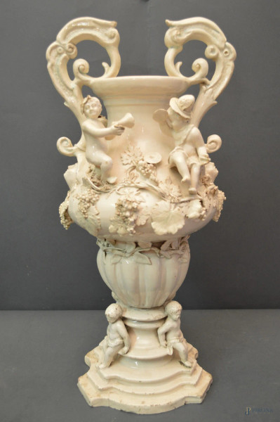 Vaso biansato in ceramica chiara a decoro di pampini d’uva e putti a rilievo, Naapoli XIX sec., h. 52 cm.